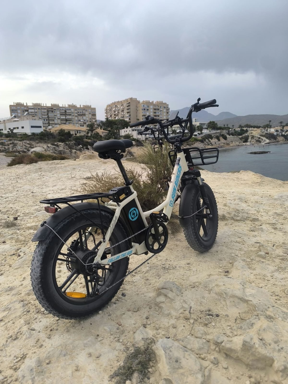 Bicicleta eléctrica urbana de alquiler con cesta y ruedas anchas en el puerto de El Campello